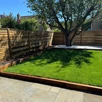 Completed garden transformation Suffolk — Finished garden with new turf, patio, and wooden fencing