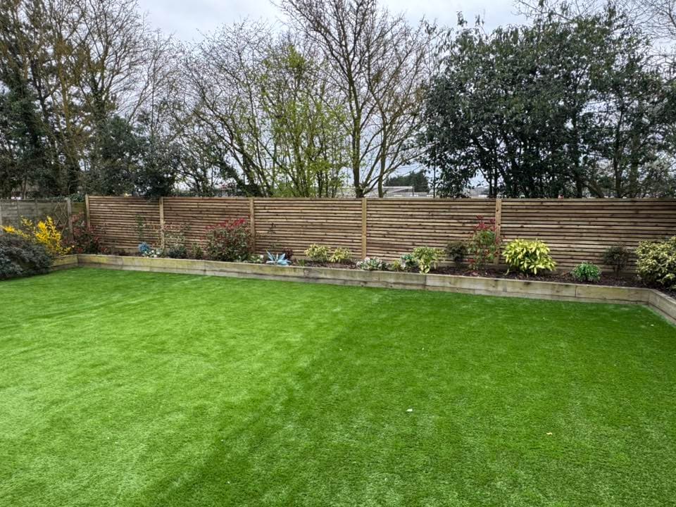 Artificial grass installation Suffolk — Bright green uniform lawn with perfect texture appearance indicates artificial grass installation