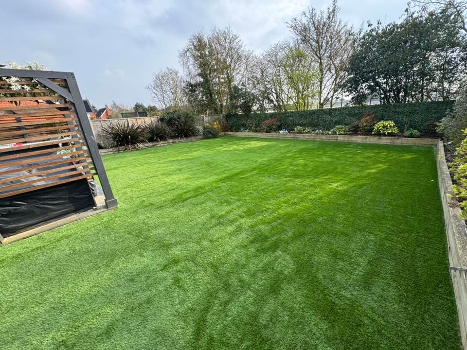 Artificial grass installation Suffolk — Bright green synthetic turf lawn with uniform appearance and visible seams