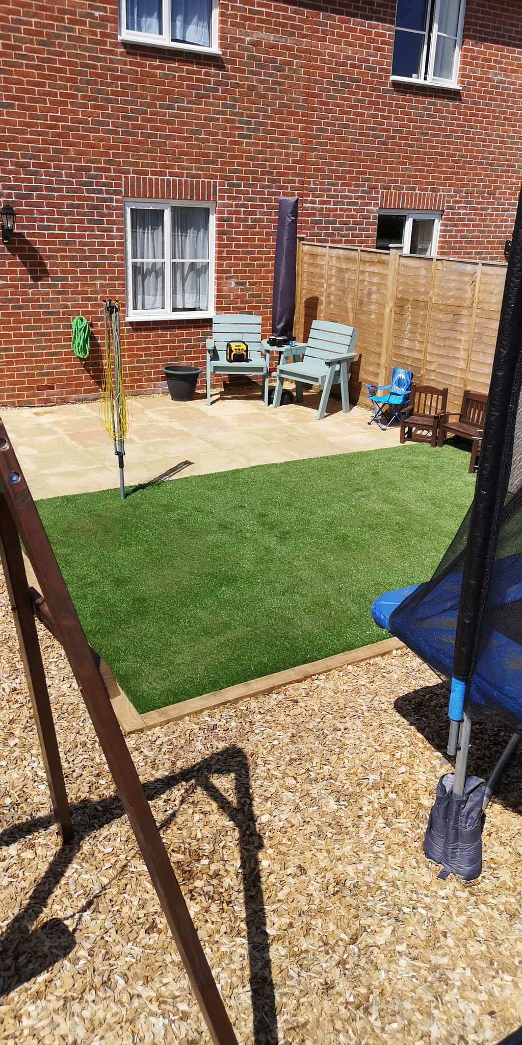Artificial grass installation Suffolk — Artificial turf installation in residential garden with patio and fencing