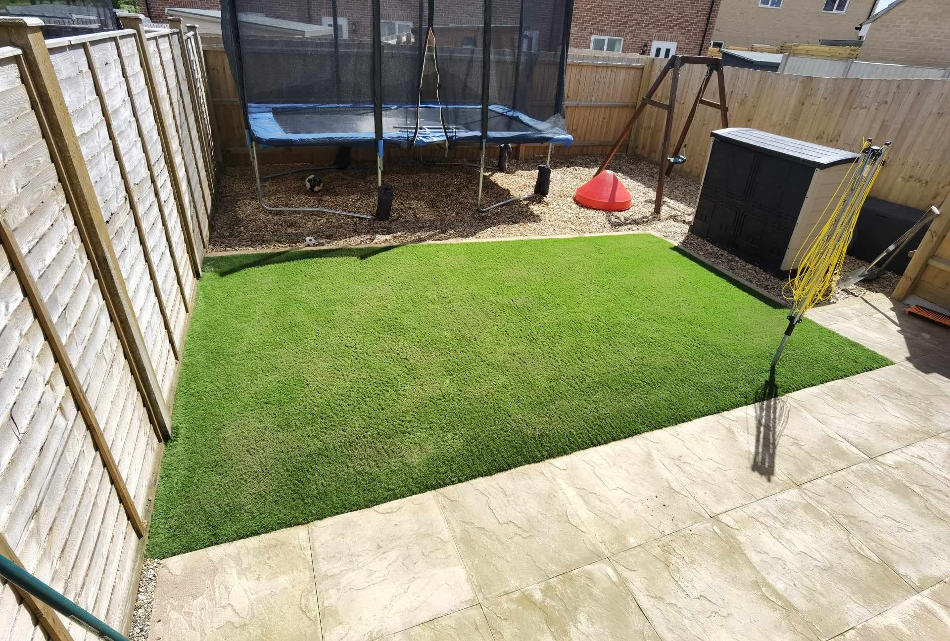 Artificial grass installation Suffolk — Bright green synthetic turf lawn installation in residential garden space