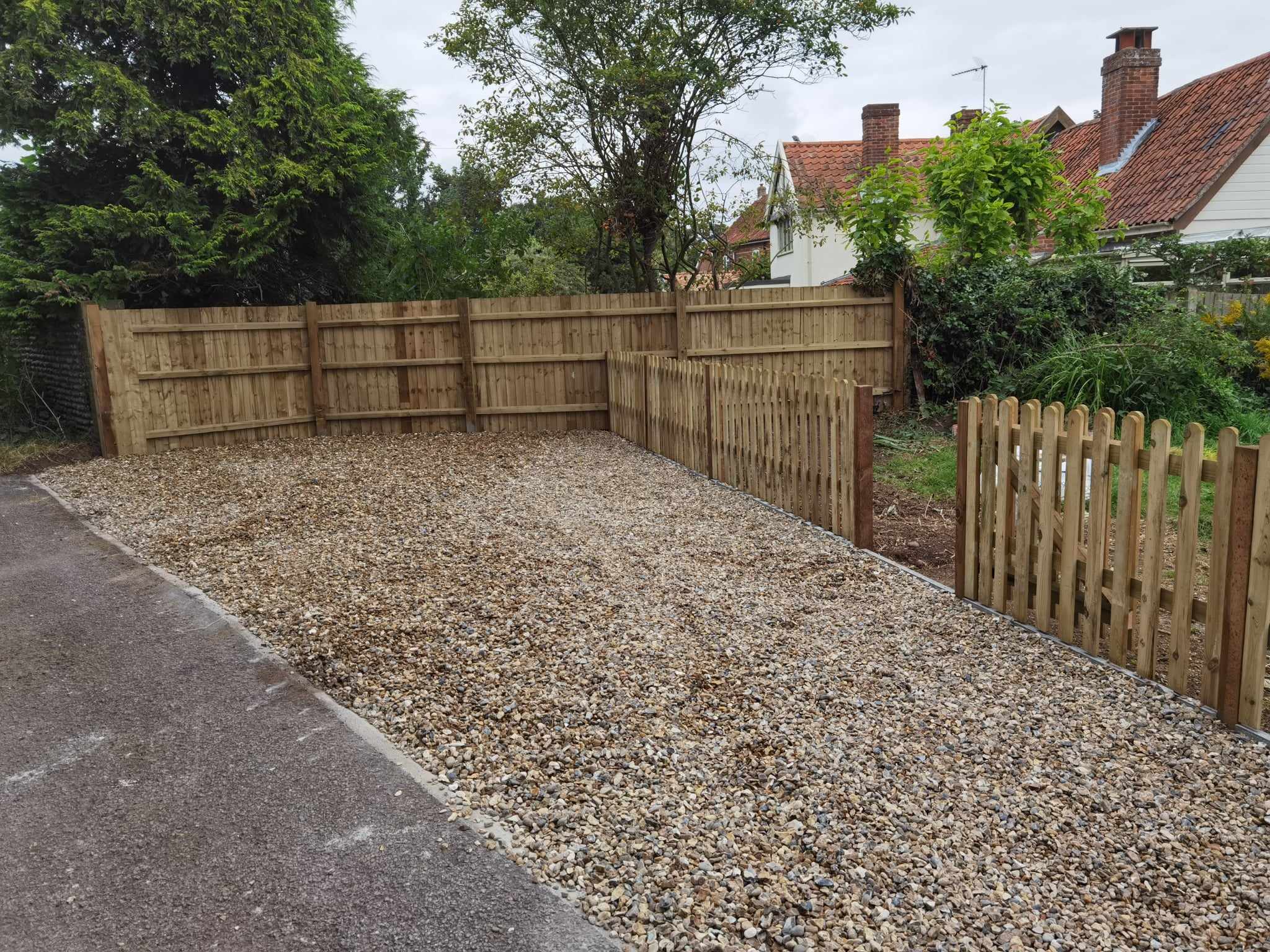 Driveway installation Suffolk — Gravel driveway with wooden fencing and gate entrance