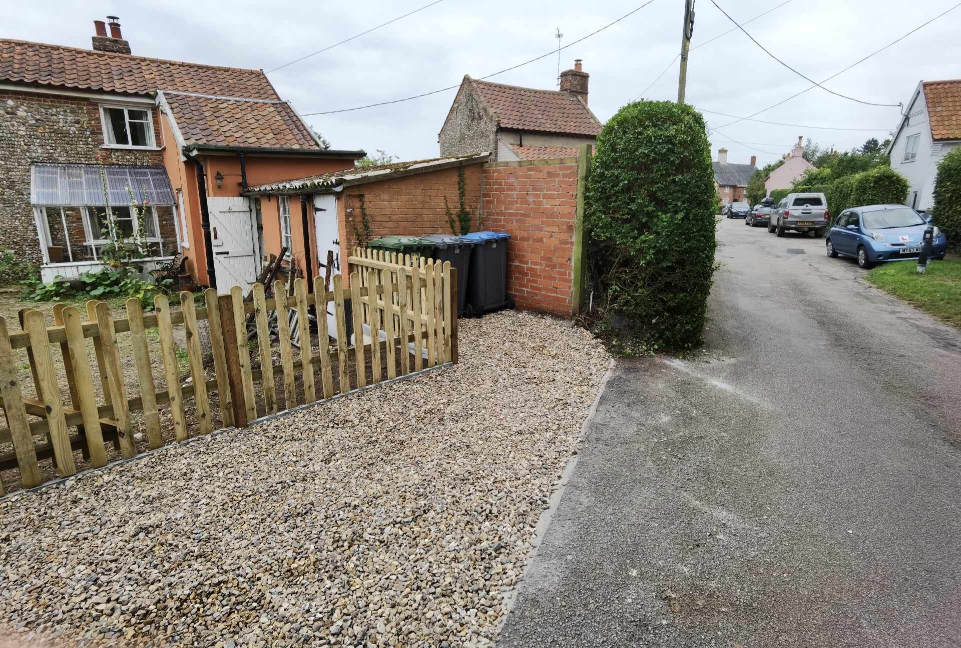 Driveway installation Suffolk — Gravel driveway with wooden fence and residential access area