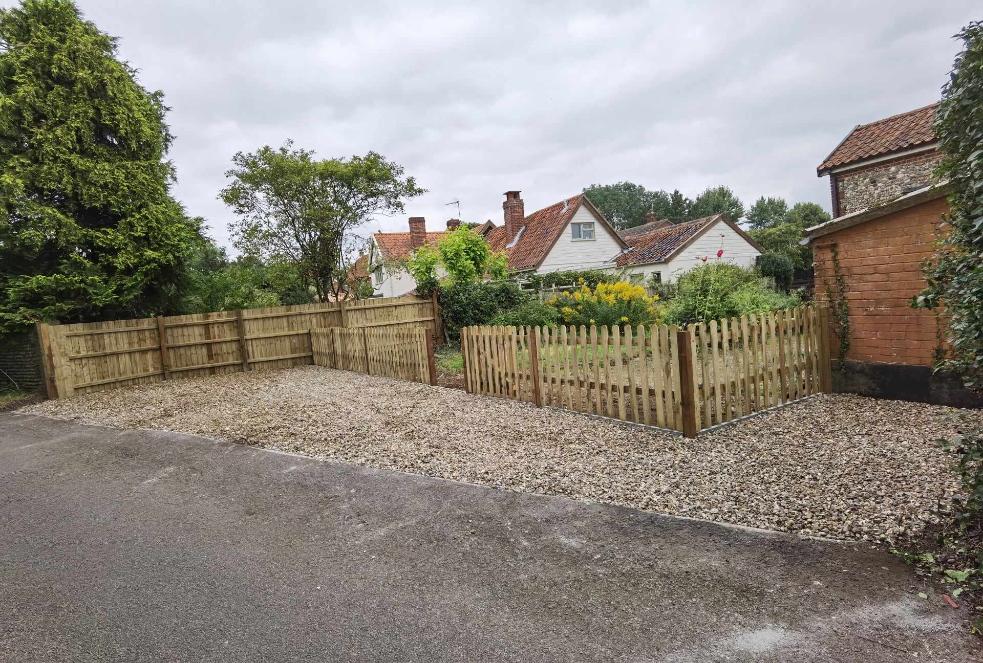 Driveway installation Suffolk — Gravel driveway with wooden fencing and rural residential setting