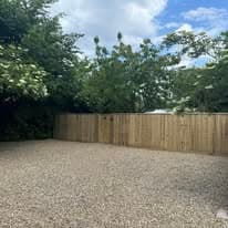 Fencing & gates Suffolk — New wooden fence panels with gravel base and mature trees backdrop