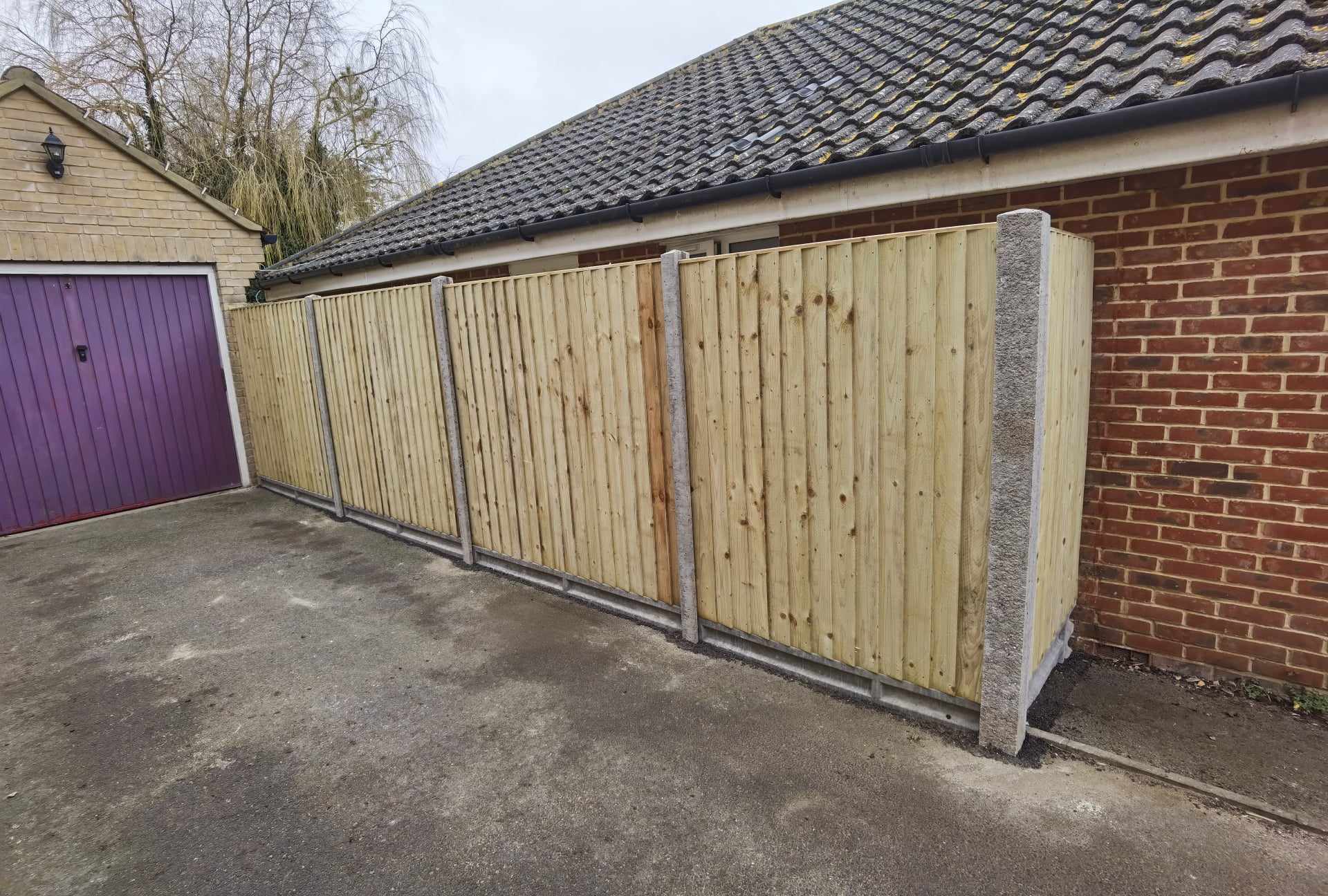 Fencing & gates Suffolk — Wooden fence panels with concrete posts along driveway area