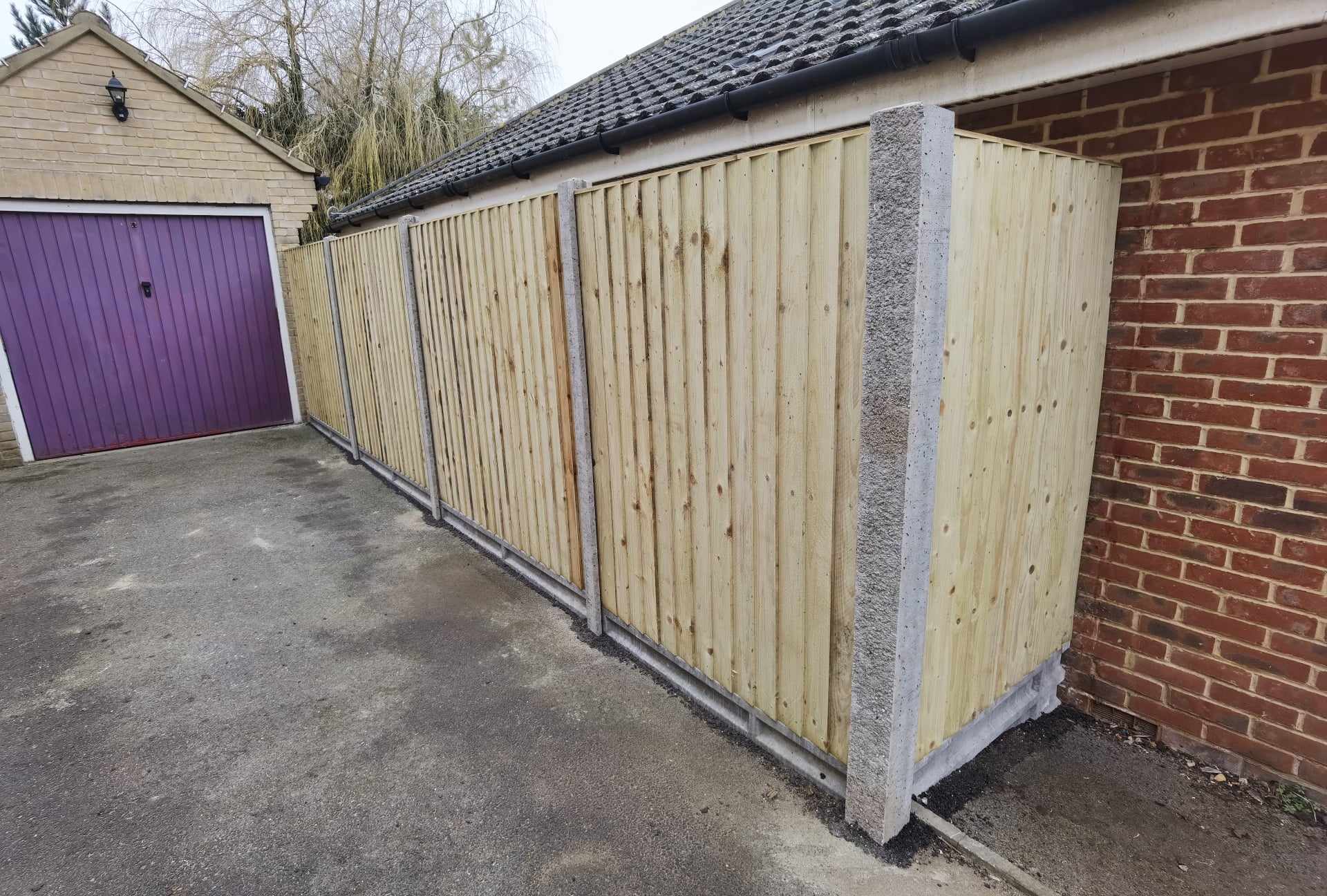 Fencing & gates Suffolk — Wooden fence with concrete posts newly installed along driveway