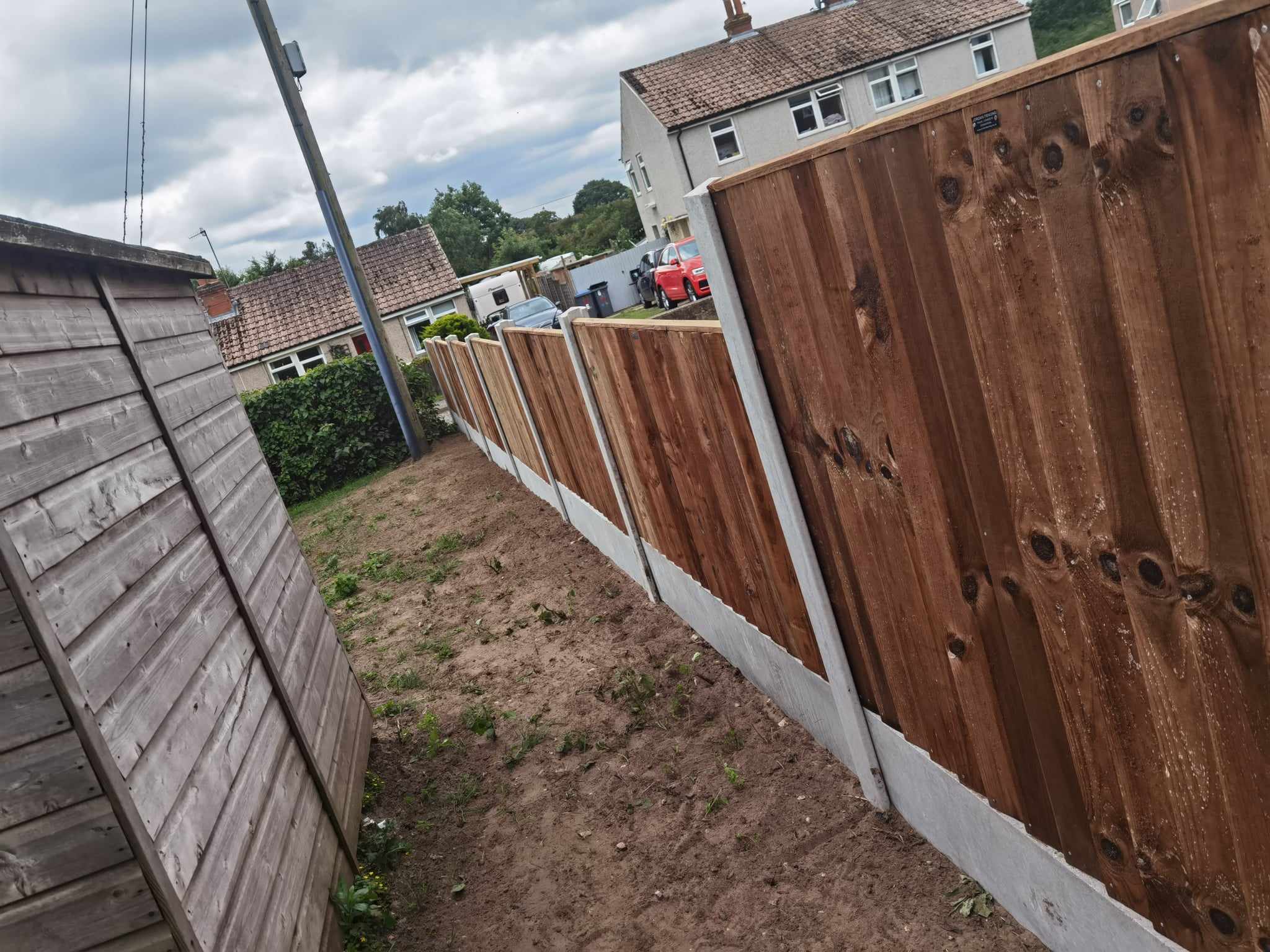Fencing & gates Suffolk — Multiple wooden fences with white concrete base panels lining pathway