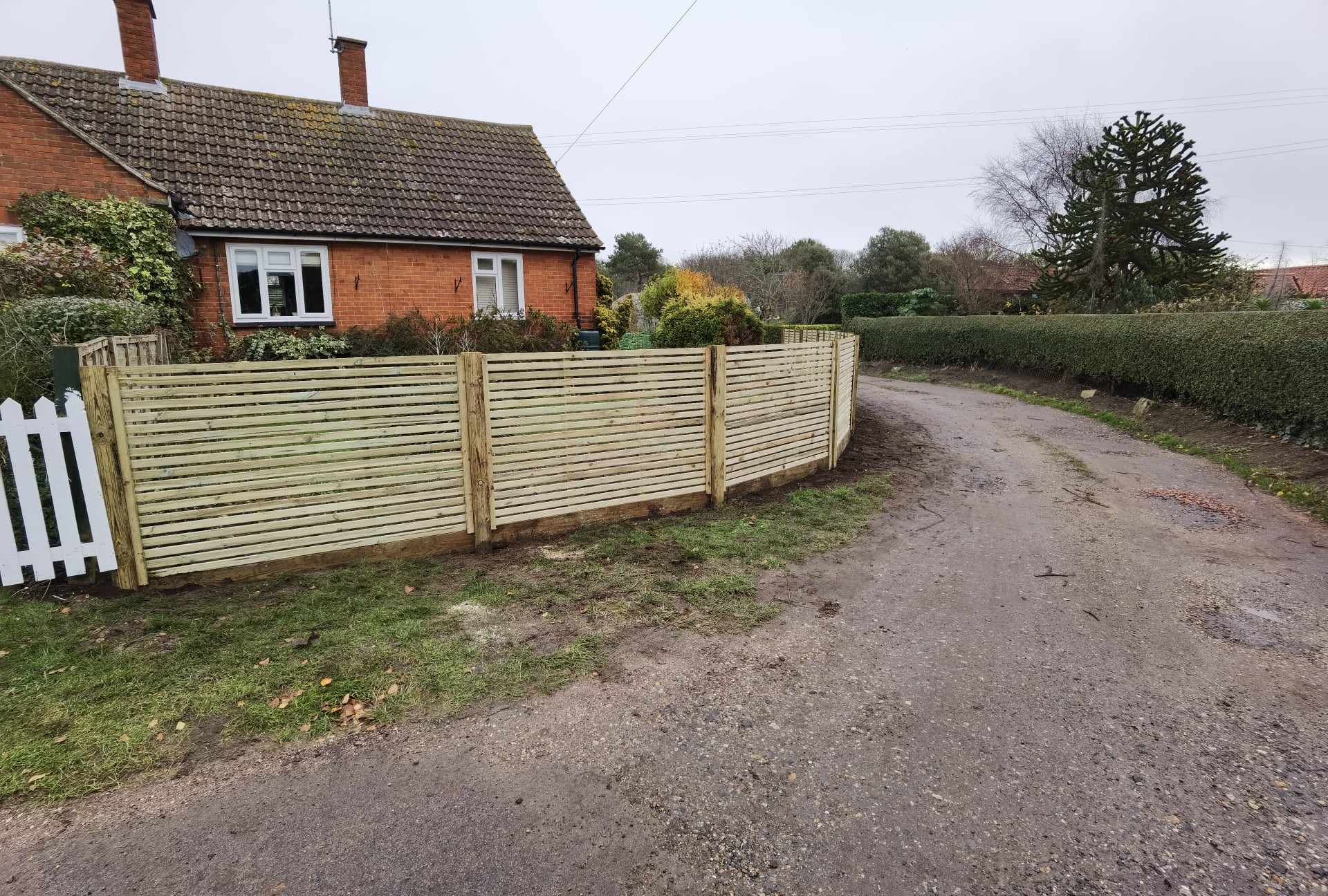 Fencing & gates Suffolk — Newly installed horizontal slatted timber fence panels along driveway