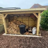 Garden landscaping project Suffolk — Wooden garden storage shed with firewood and garden equipment