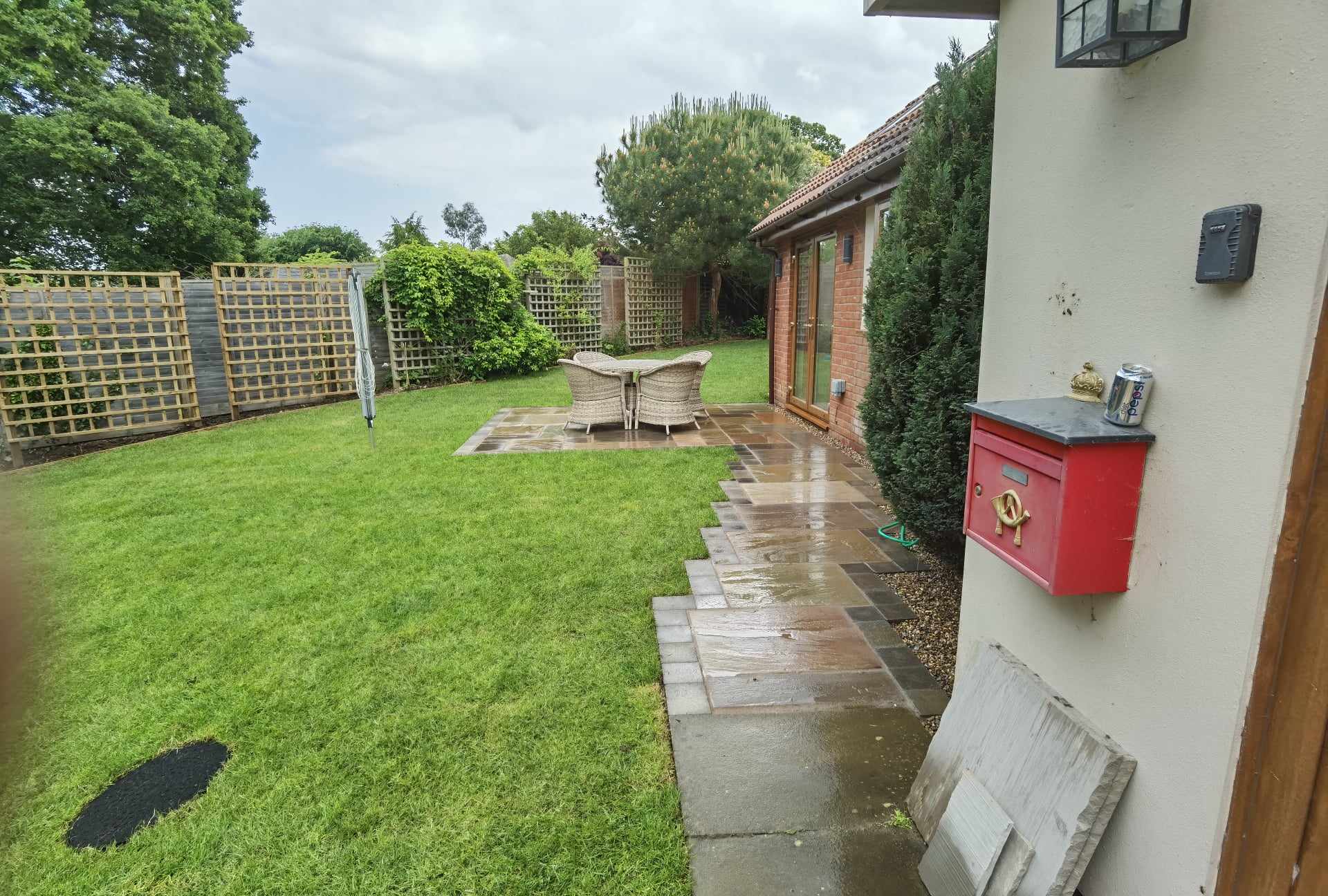 Garden landscaping project Suffolk — Wide garden view showing landscaped patio, lawn, fencing, and property