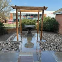 Patio installation Suffolk — Stone slab patio with pergola, gravel borders, and landscaping features