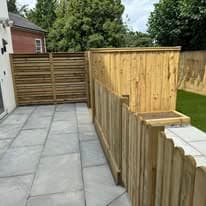 Patio installation Suffolk — Grey porcelain slabs with new wooden fencing installation visible
