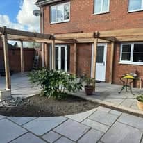 Patio installation Suffolk — Stone slab paved courtyard area with seating space behind brick house