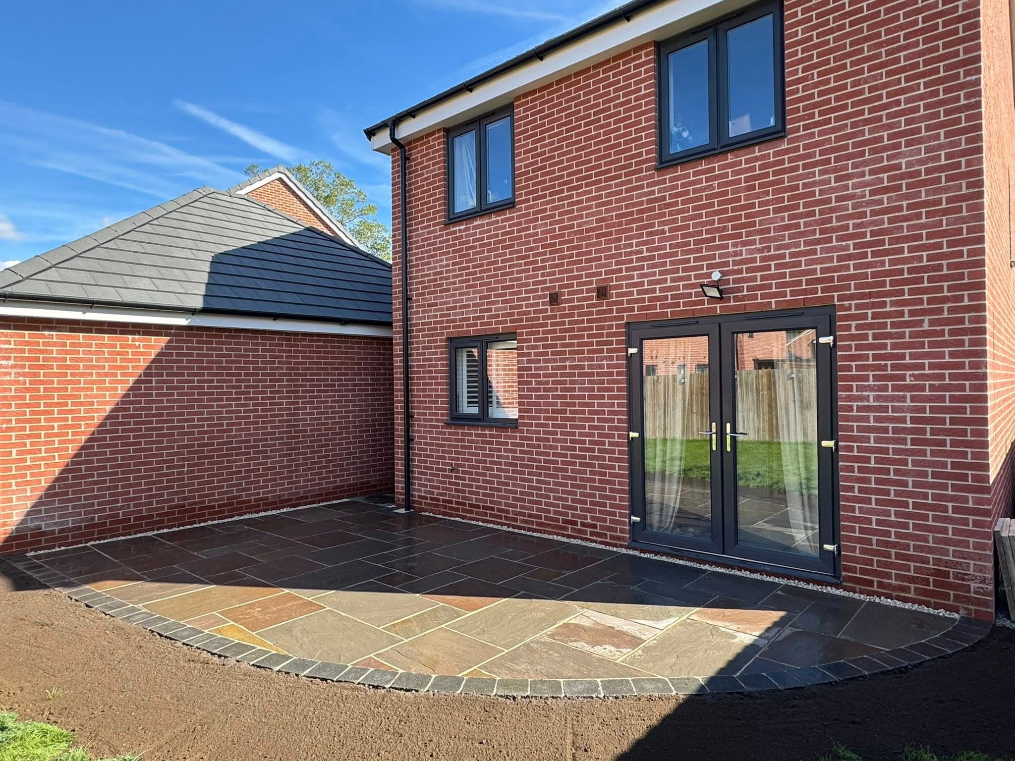 Patio installation Suffolk — Mixed stone paving with dark slate and sandstone in herringbone pattern