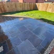 Patio installation Suffolk — Dark slate stone patio with geometric layout in backyard