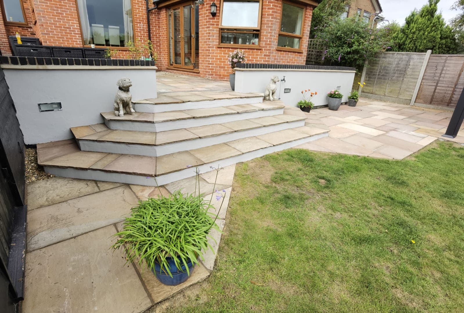 Patio installation Suffolk — Large stone slab patio with tiered steps and landscaped garden