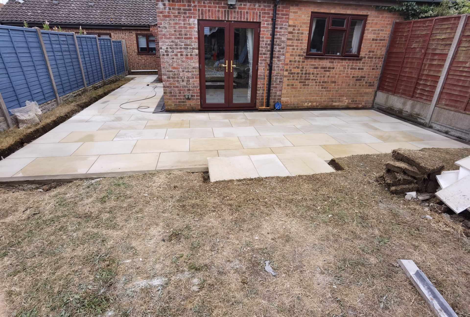 Patio installation Suffolk — Natural stone slab patio installation in progress in rear garden