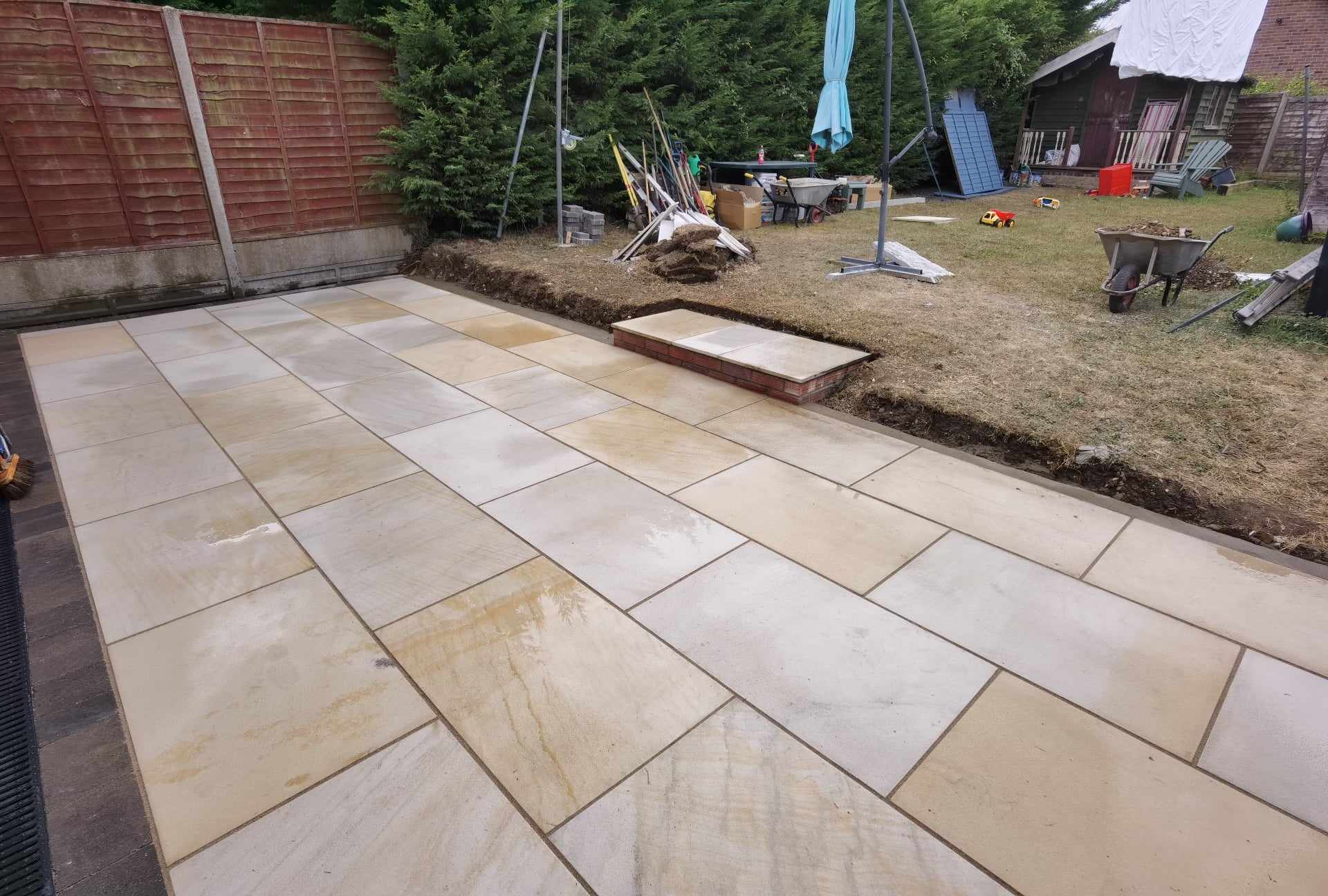 Patio installation Suffolk — Large stone slab patio with sandstone pavers in herringbone pattern layout