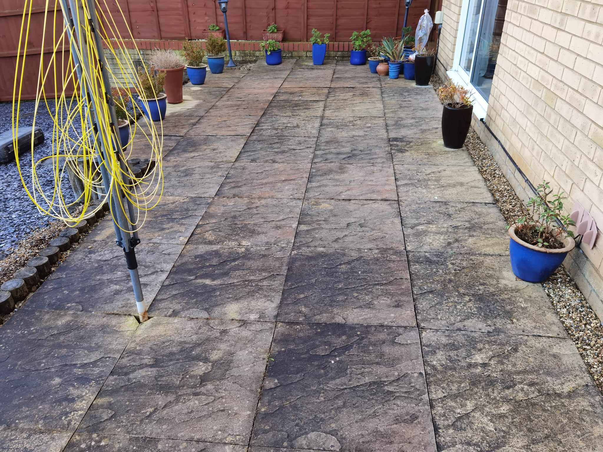 Patio installation Suffolk — Dark slate paved patio area with potted plants and garden furniture