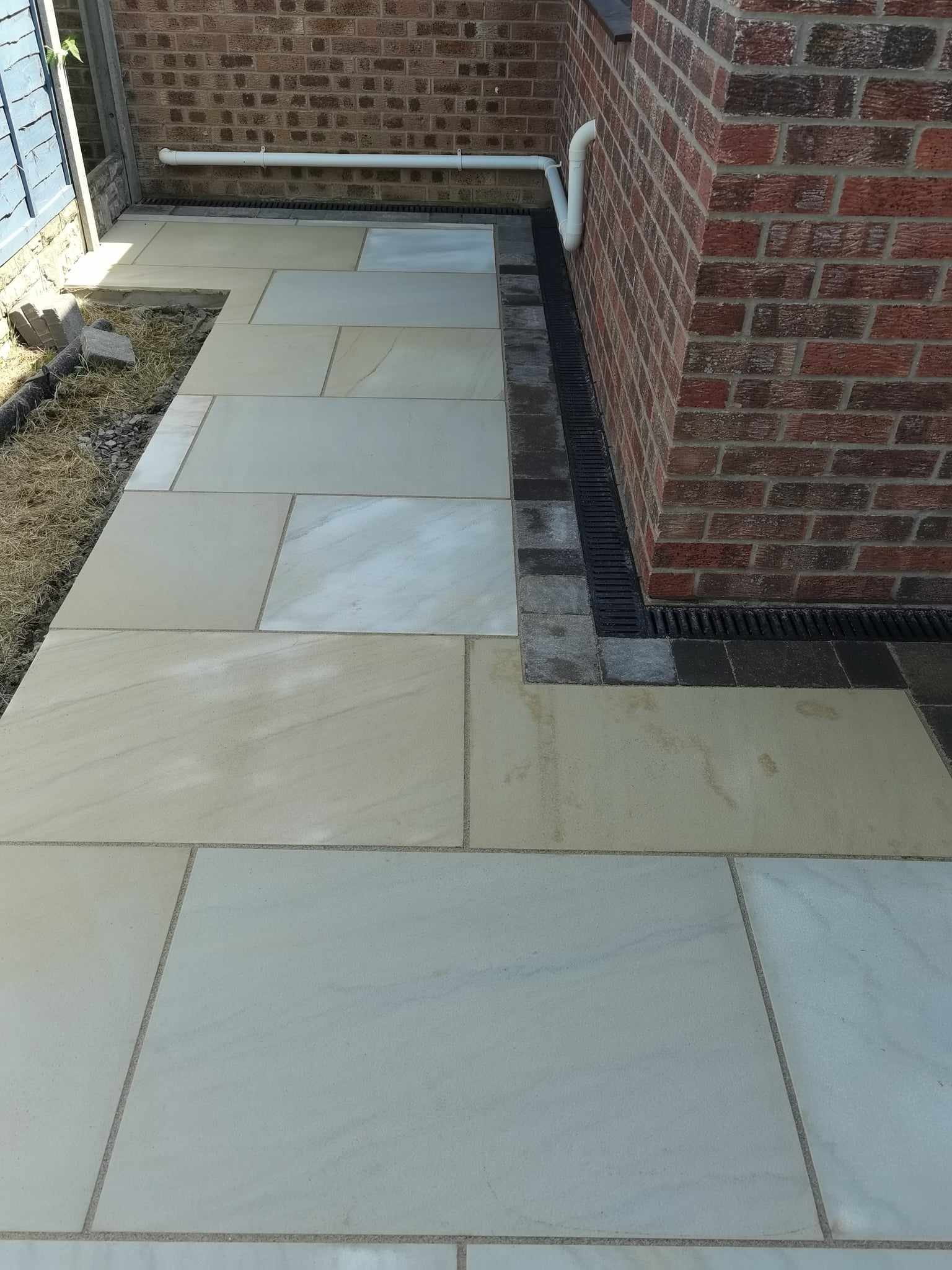 Patio installation Suffolk — Large porcelain paved patio with brick surround and drainage system