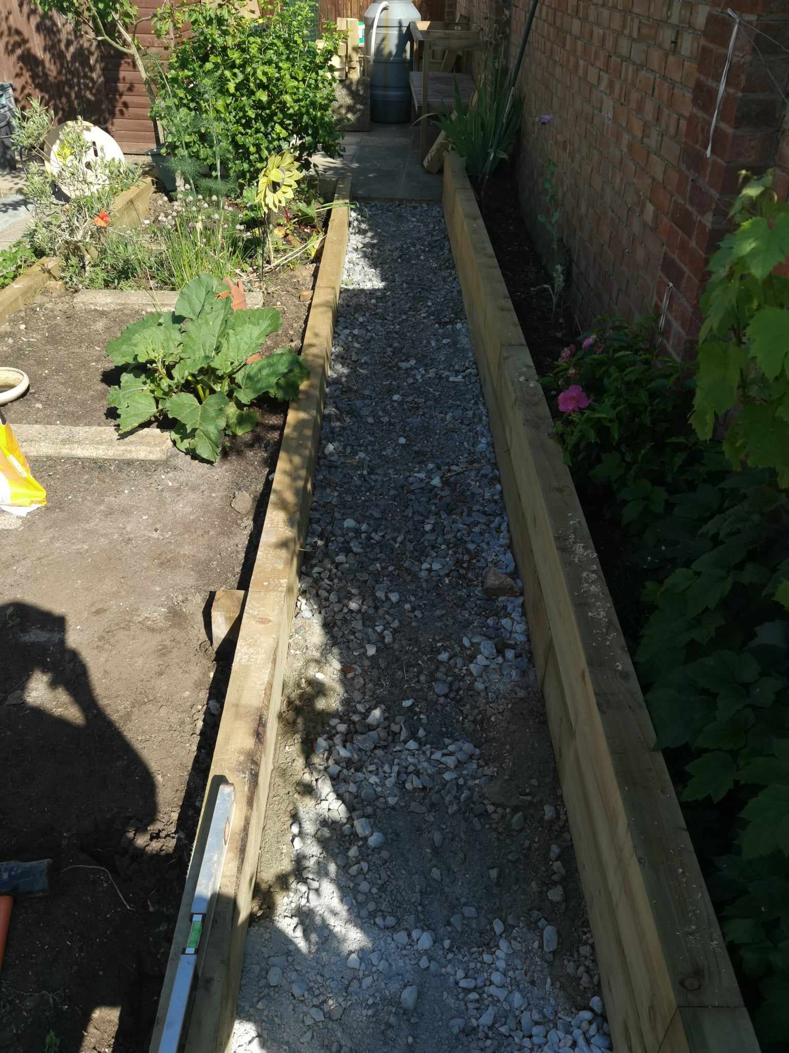 Raised bed garden Suffolk — Wooden raised bed with gravel and various flowering plants growing