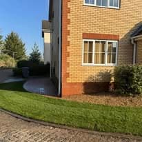 Turfing & lawn Suffolk — Well-maintained grass lawn beside brick residential property