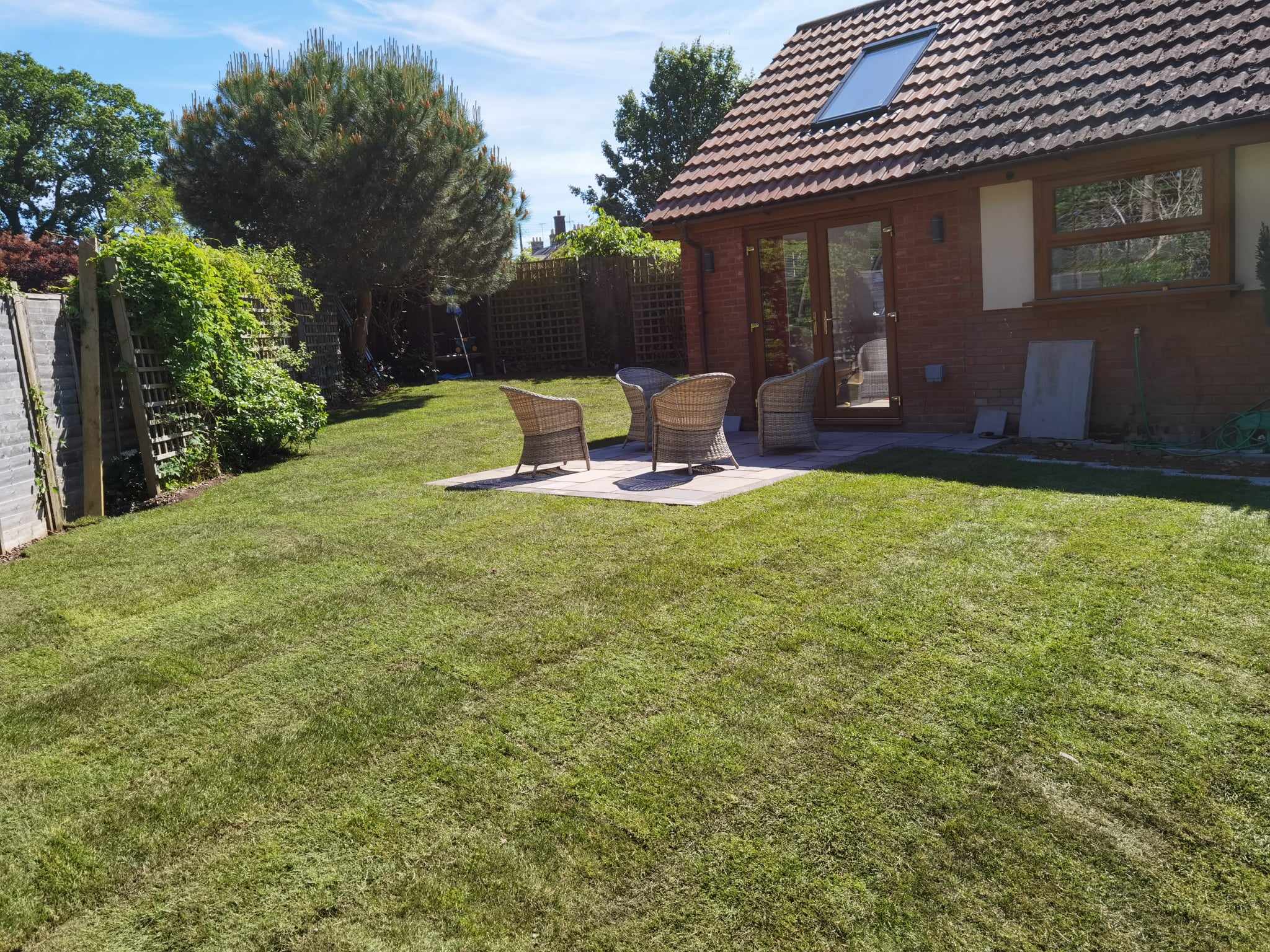 Turfing & lawn Suffolk — Well-maintained real grass lawn in residential garden setting